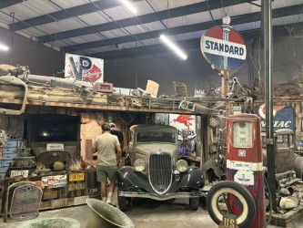 Indoor shop visit — Standard Oil signage, vintage parts collection