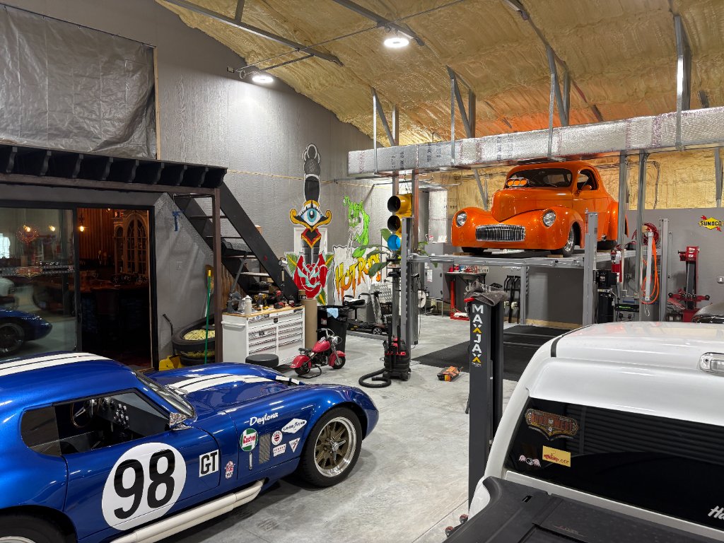 Shop floor — Shelby Daytona #98, orange Willys on MAXJAX lift, Hot Rod mural