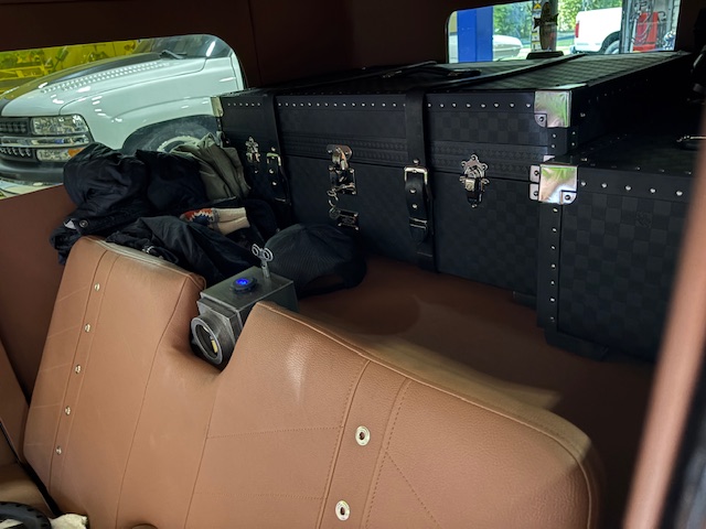 Interior — custom tan leather rear seat, luxury luggage set