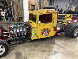 Yellow rat rod truck — "Gnarly" Joker face art, drag setup