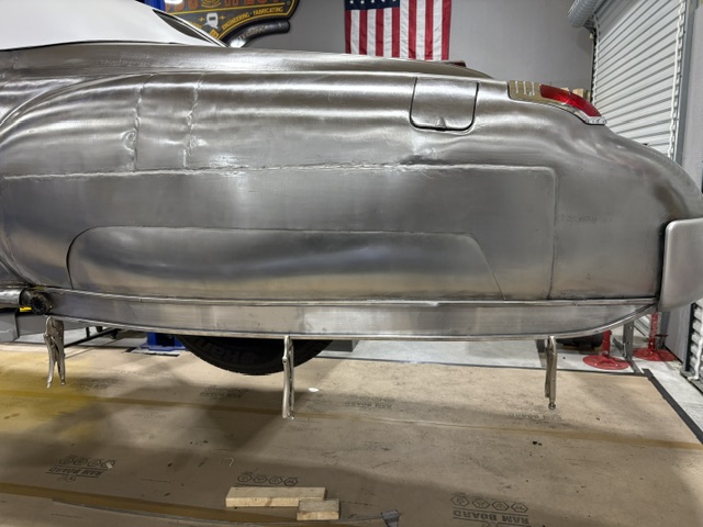 Rear quarter close-up — hand-formed panel fitted and clamped