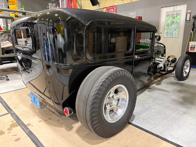 Rear three-quarter — slammed stance, fat rear tires, gloss black finish