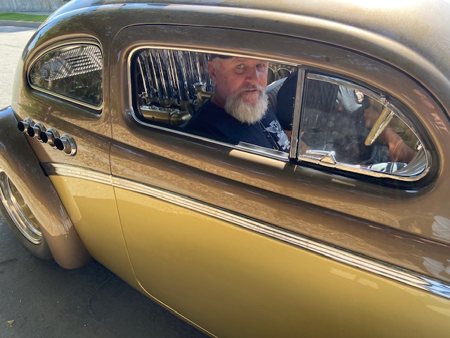 Wayne in the driver's seat — copper custom, on the road