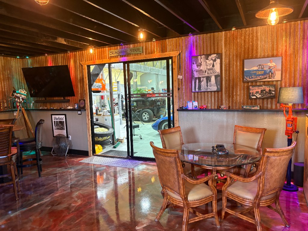 Lounge — Sunshine State sign, corrugated walls, epoxy marble floors, view into shop