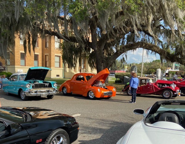 1941 Willys at a Florida car show — vibrant orange, hood open, crowd favorite