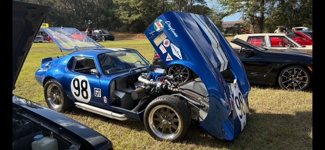 At a car show — hood up, race-spec engine on display