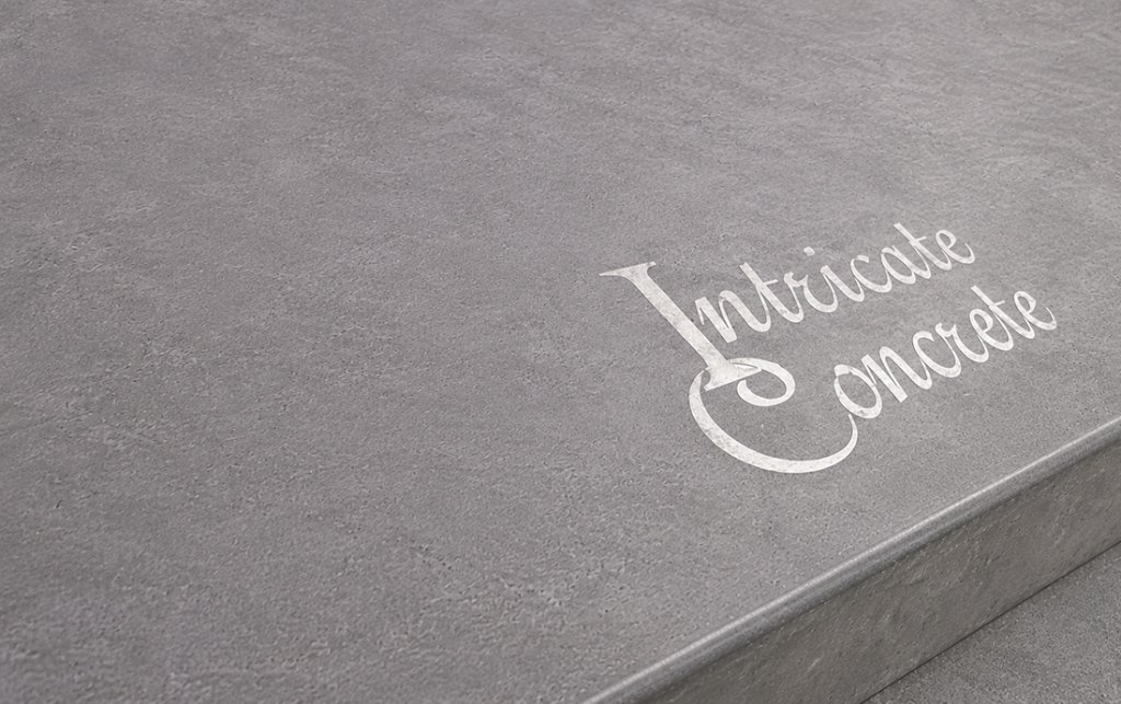 Smooth grey concrete surface with the Intricate Concrete logo stenciled in a weathered off-white finish