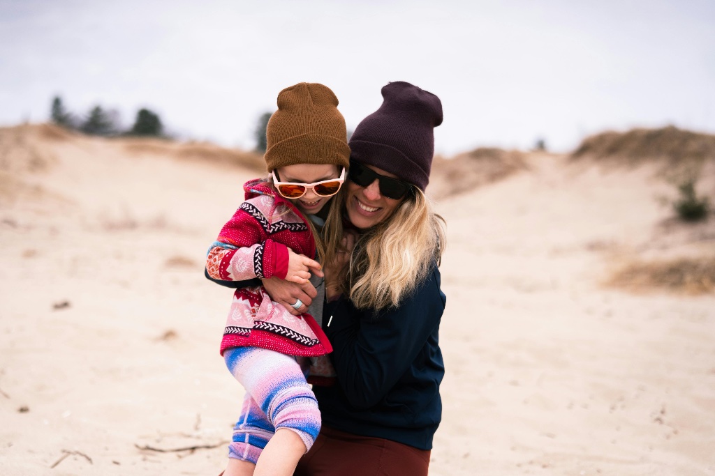 Family embracing on the beach in sunglasses