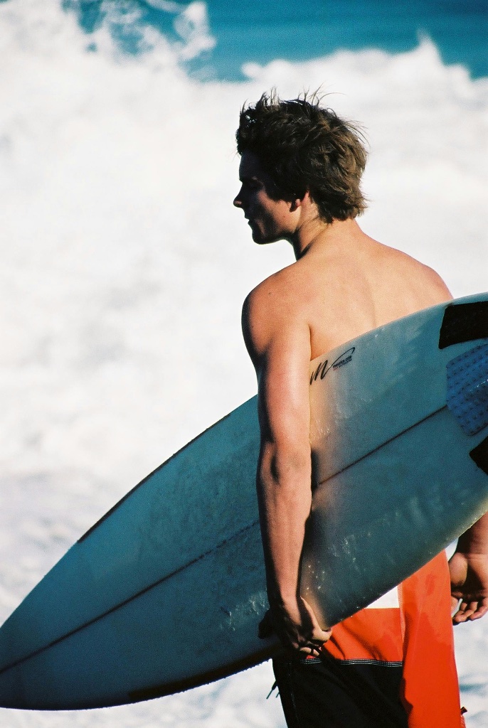 Surfer exiting the water with board