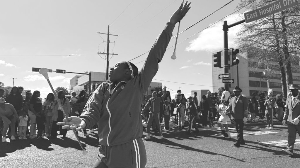A dancer raises her arm triumphantly during a New Orleans second line parade