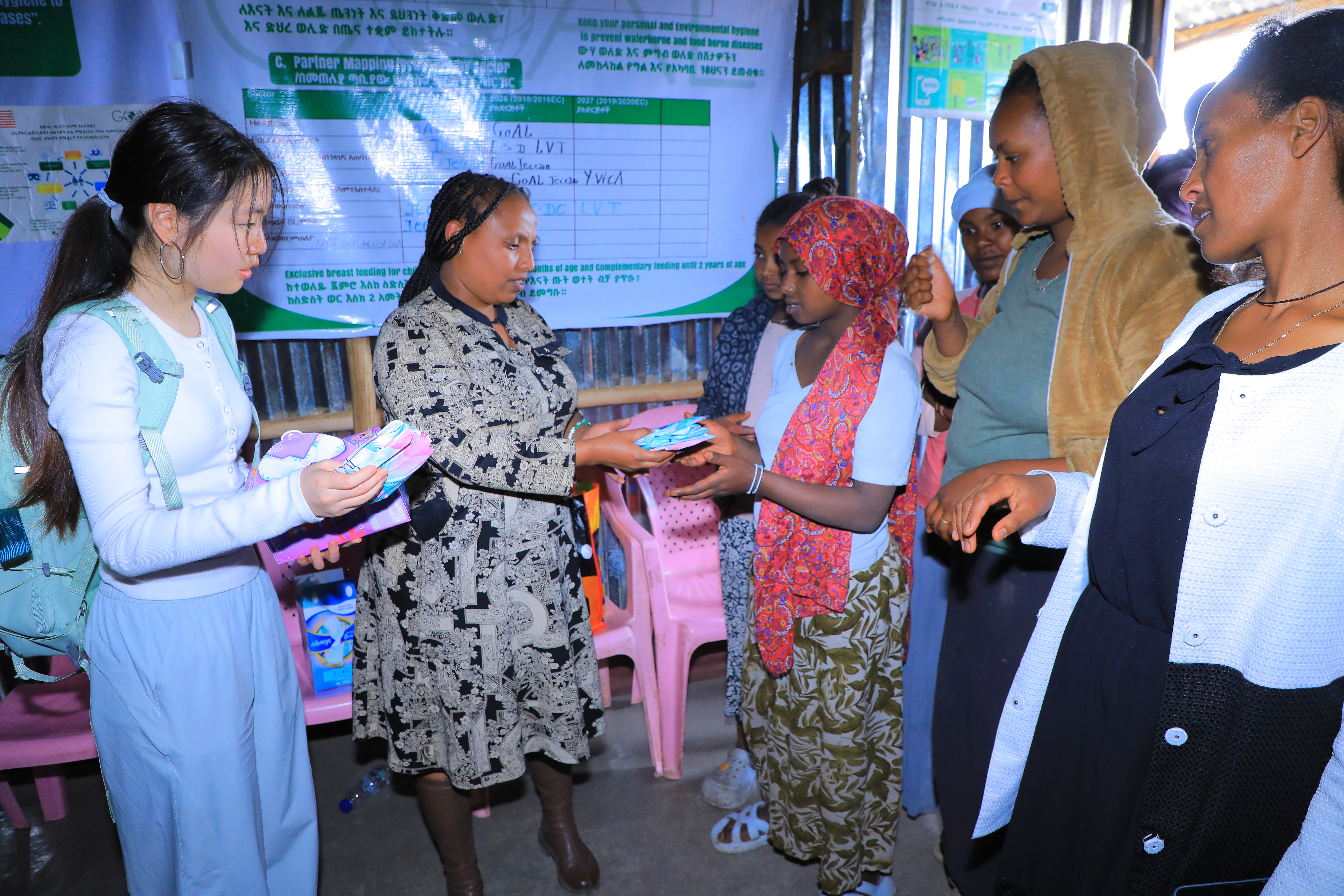 Handing out menstrual hygiene kits to young women in the community.