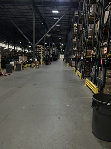 Warehouse facility before and after an ecoZohm LED upgrade — Rack row main aisle — before