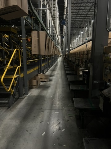 Warehouse facility before and after an ecoZohm LED upgrade — Stair access & put wall aisle — before