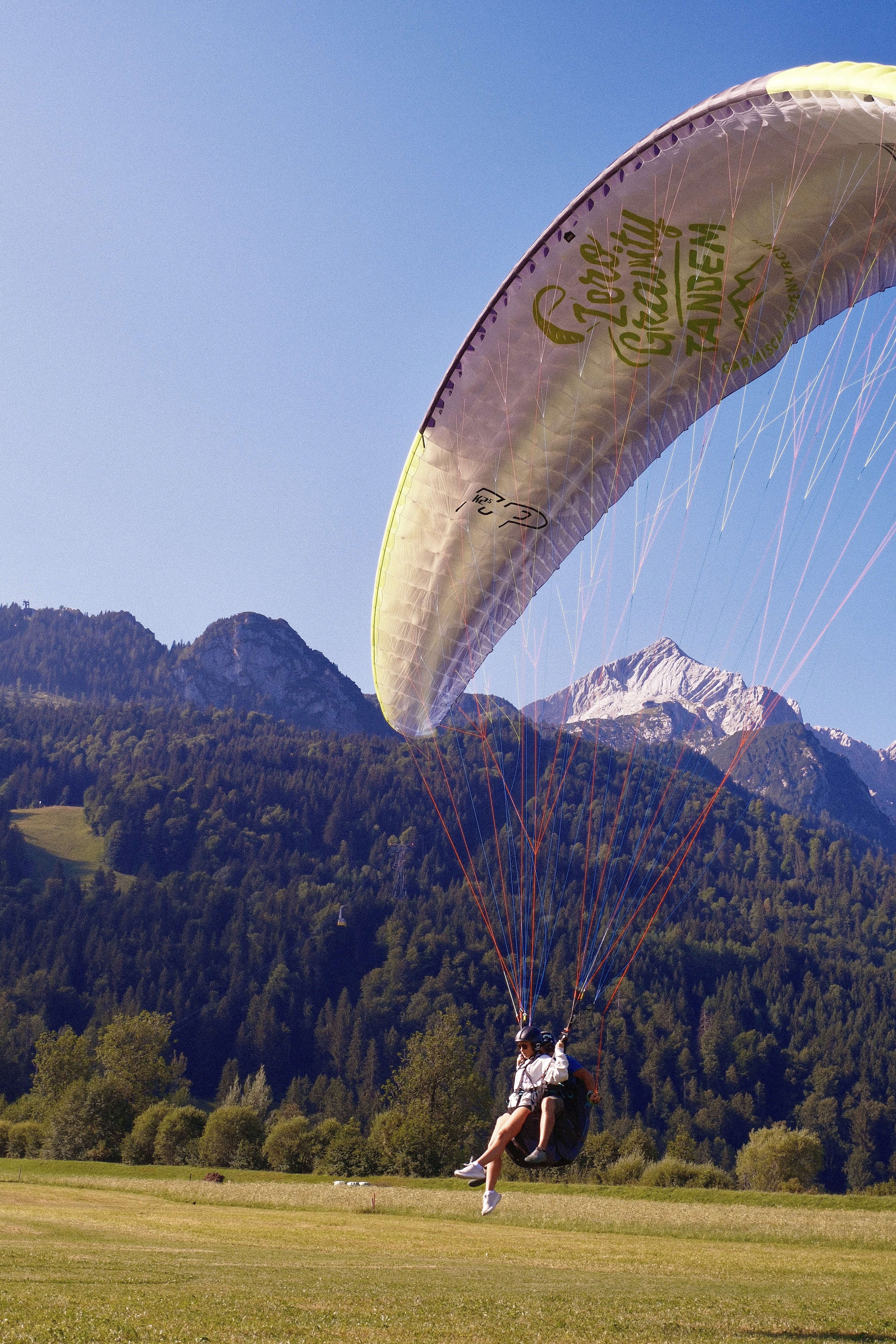 Gleitschirm vor Bergmassiv im Gegenlicht