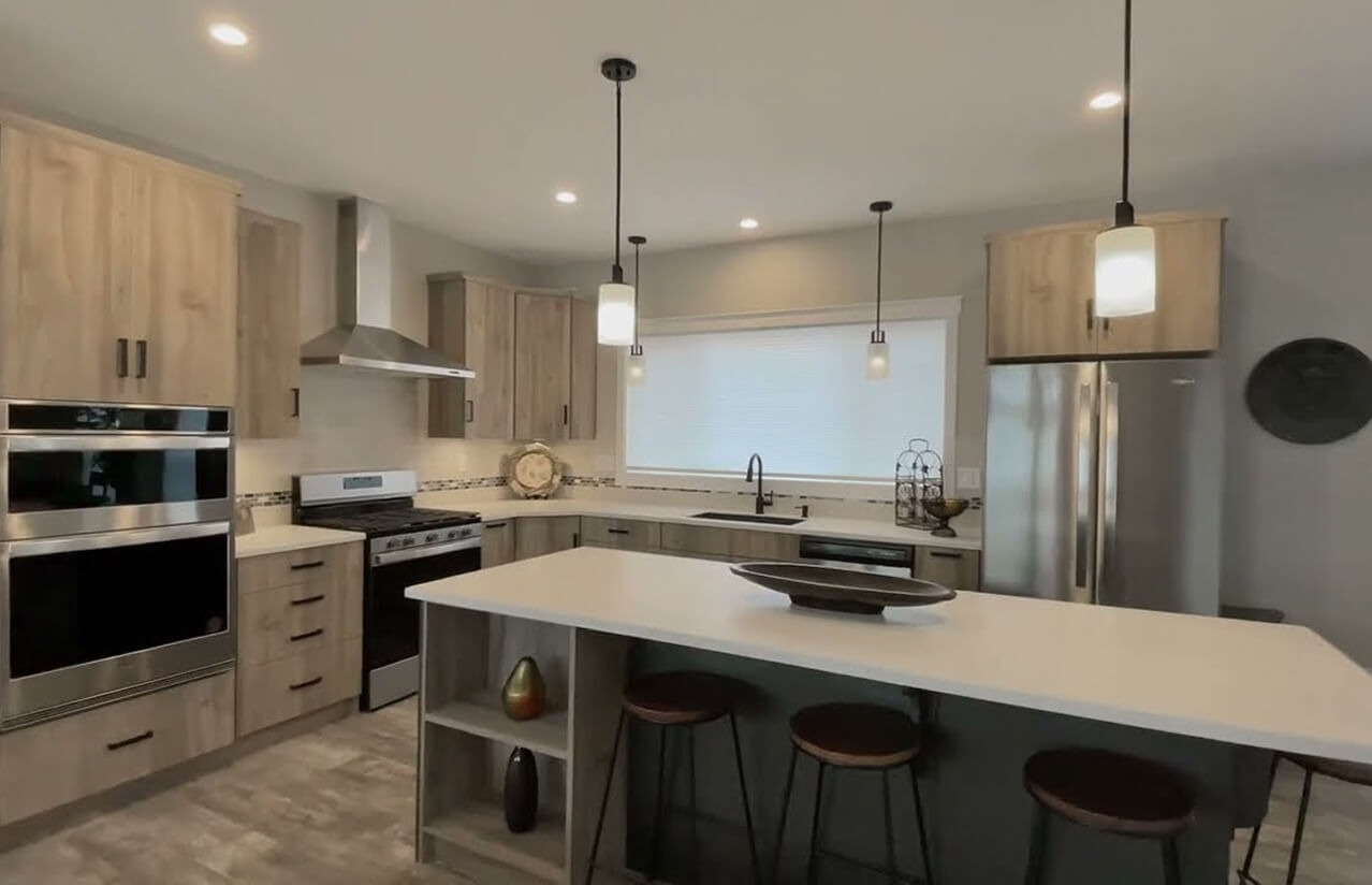 Modular home kitchen with light wood cabinets and a breakfast island
