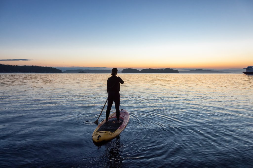 Woman on stand-up paddleboard at sunset on Lake Hartwell