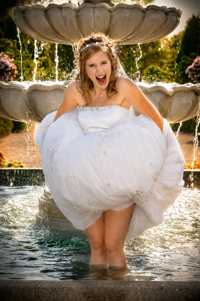 Bride splashing in a wishing fountain in Ontario