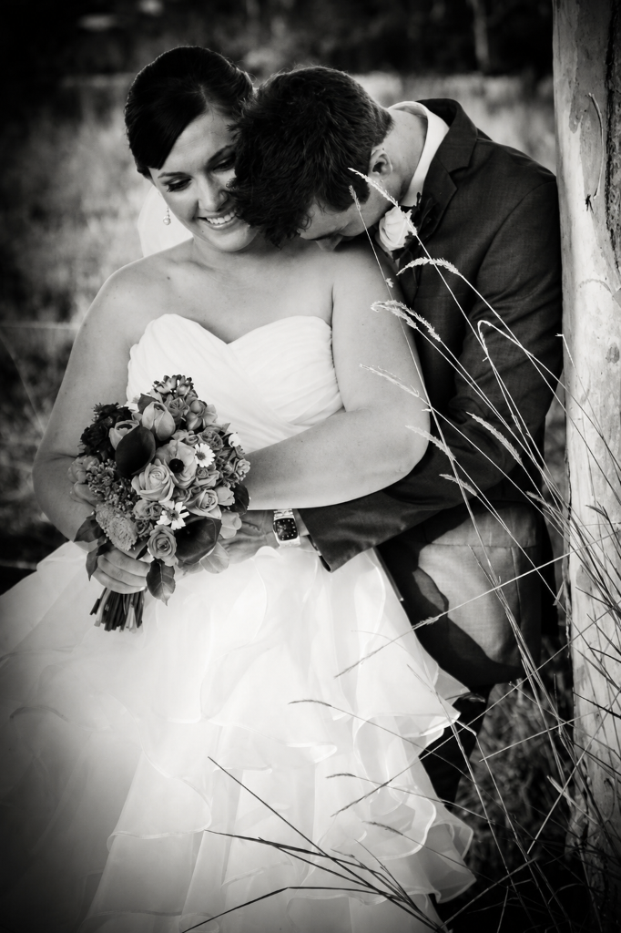 Intimate black and white portrait of Amy & Reace by a fence in a field