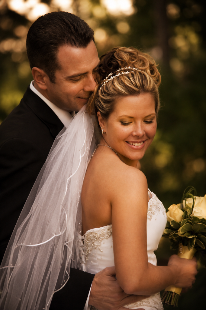 Bride and groom in intimate embrace, soft golden hour glow