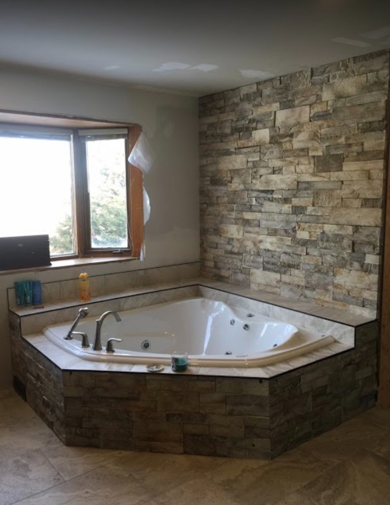 Interior stone feature wall and tub surround with detailed masonry