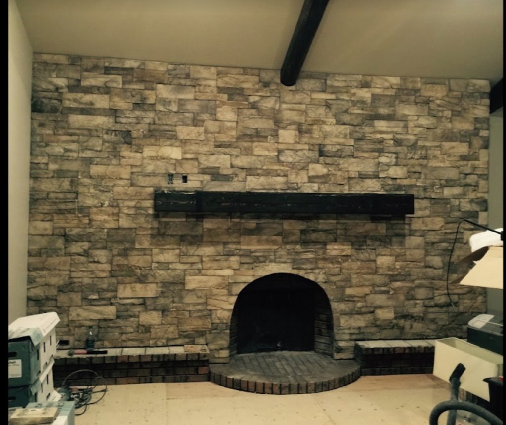 Charcoal paving stone entrance patio with retaining wall and stone facade