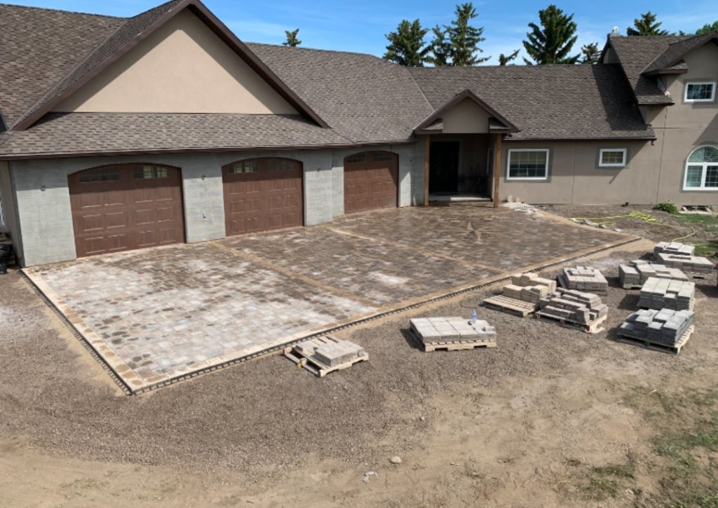 Large paving stone driveway installation in progress at residential home