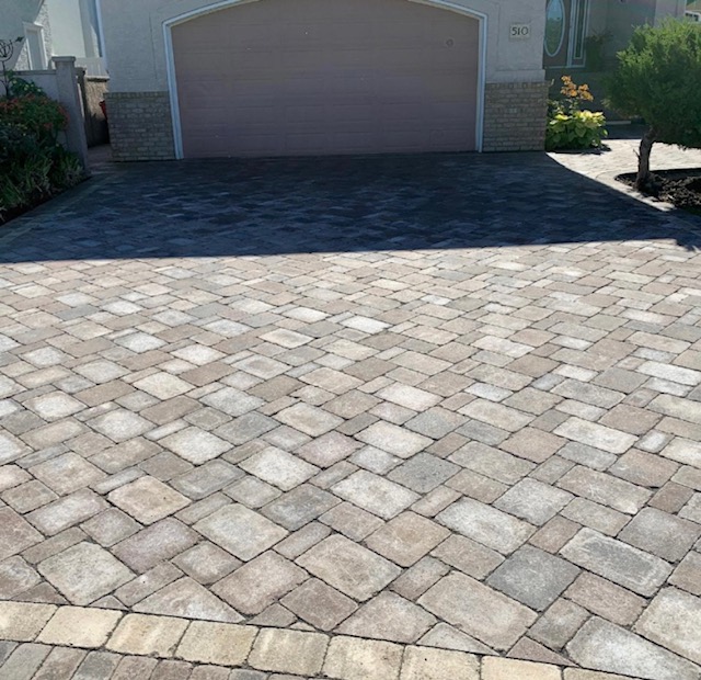 Large interlocking paving stone driveway in front of a residential garage