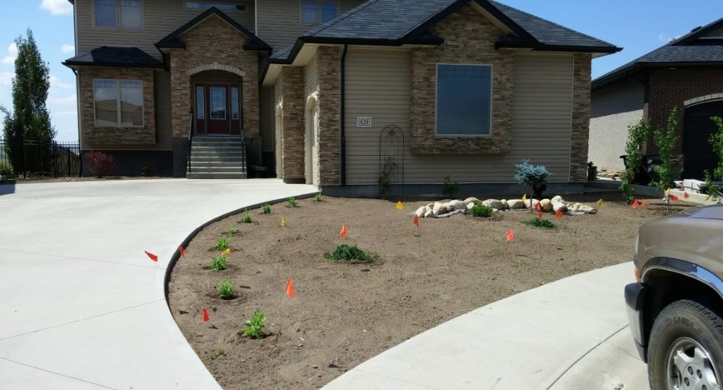 New landscape planting bed installation in front of two-storey home