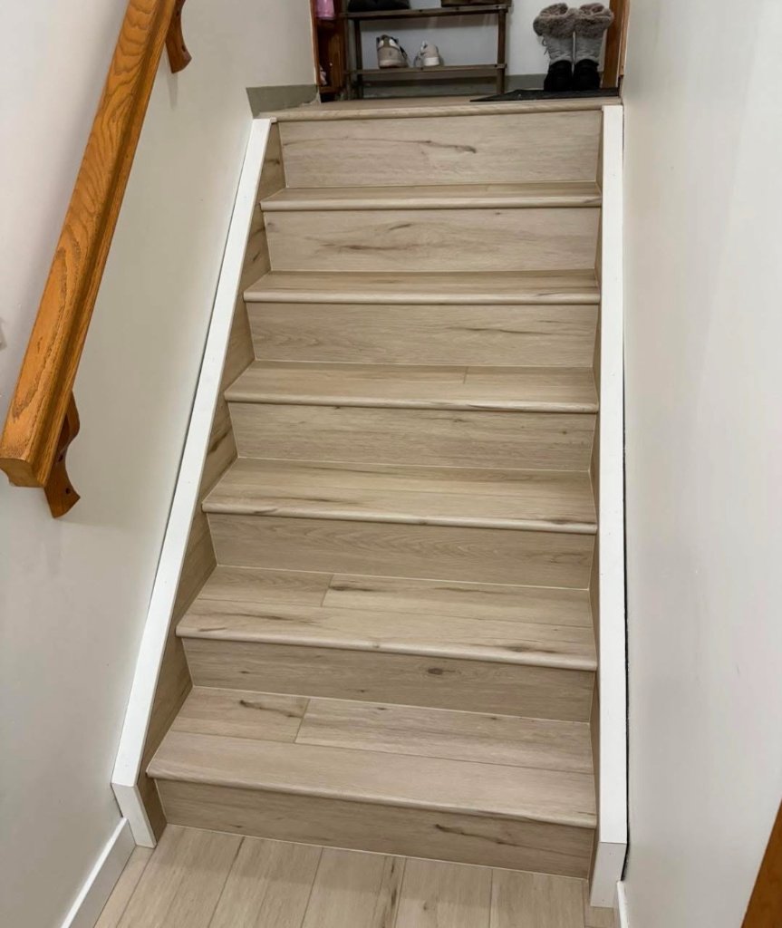 Luxury vinyl plank flooring installed in kitchen with white cabinets