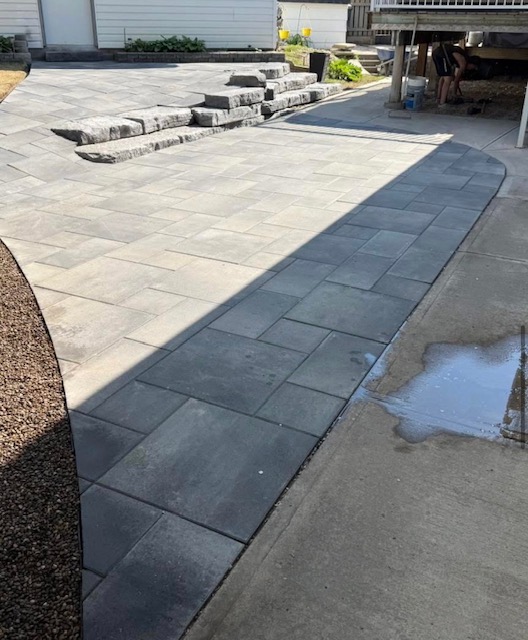 Grey paving stone patio with stone step detail in Medicine Hat backyard