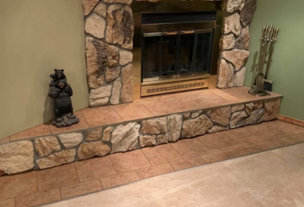 Stone fireplace surround with natural rock detail in living room