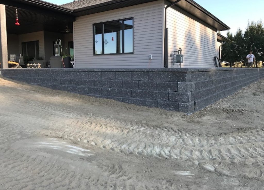 Large charcoal retaining wall built around a residential patio area