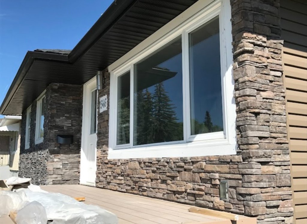 Stone veneer exterior detail around windows and front entrance