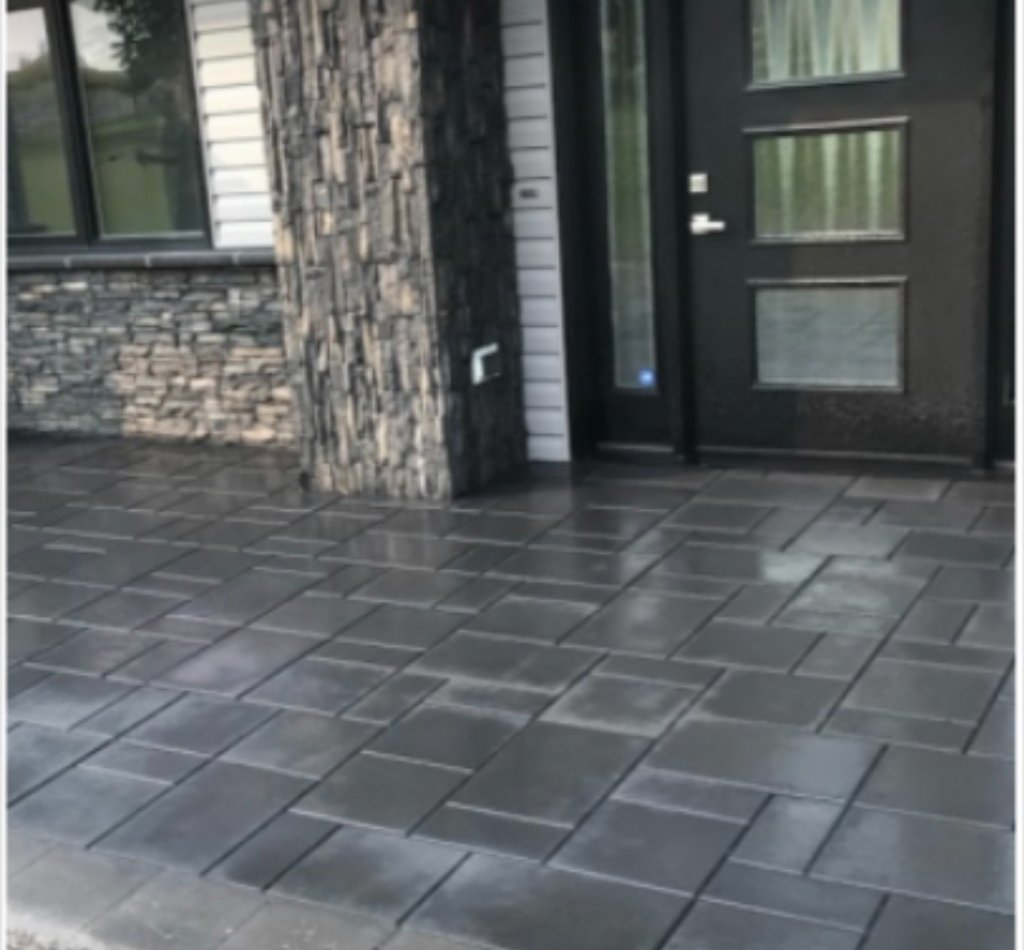 Dark paving stone patio at the front entrance of a home