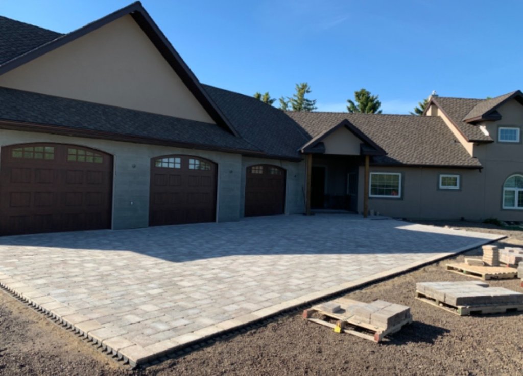 Large paving stone driveway installation in front of triple car garage