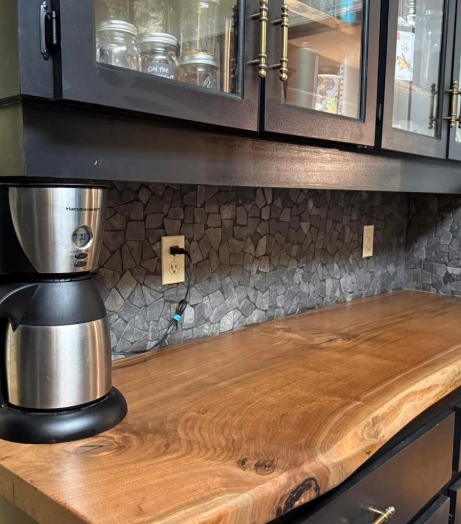 Kitchen backsplash with dark stone detail and wood countertop