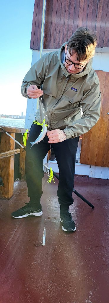 Medlem med fisk og neon-gul jig på dækket