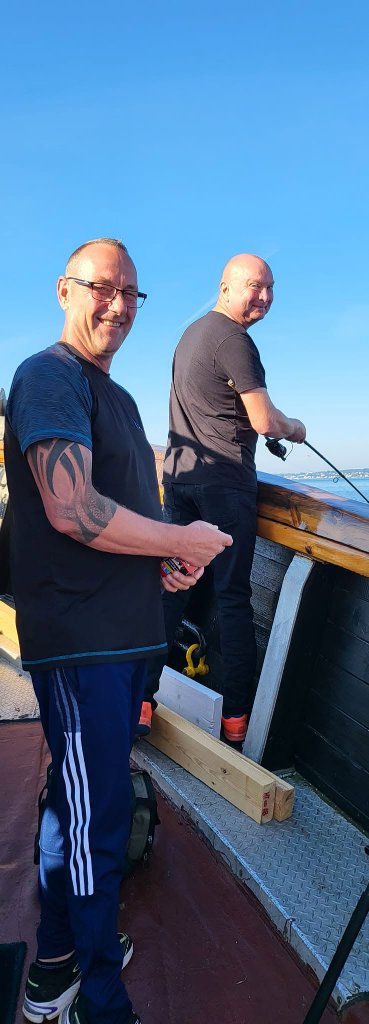 To medlemmer fisker fra dækket med smil og god stemning