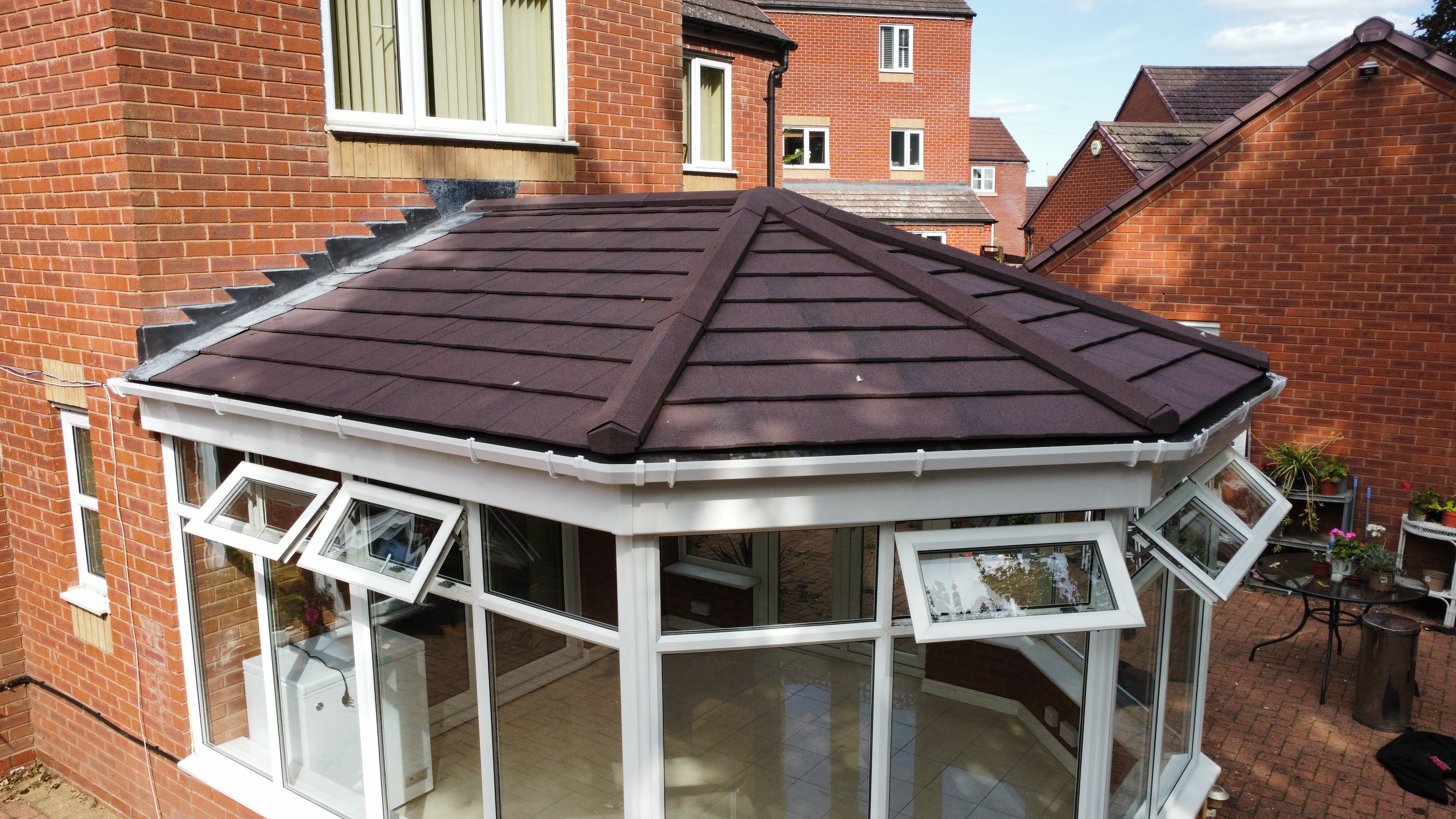 Drone view of completed conservatory with dark brown tiled roof