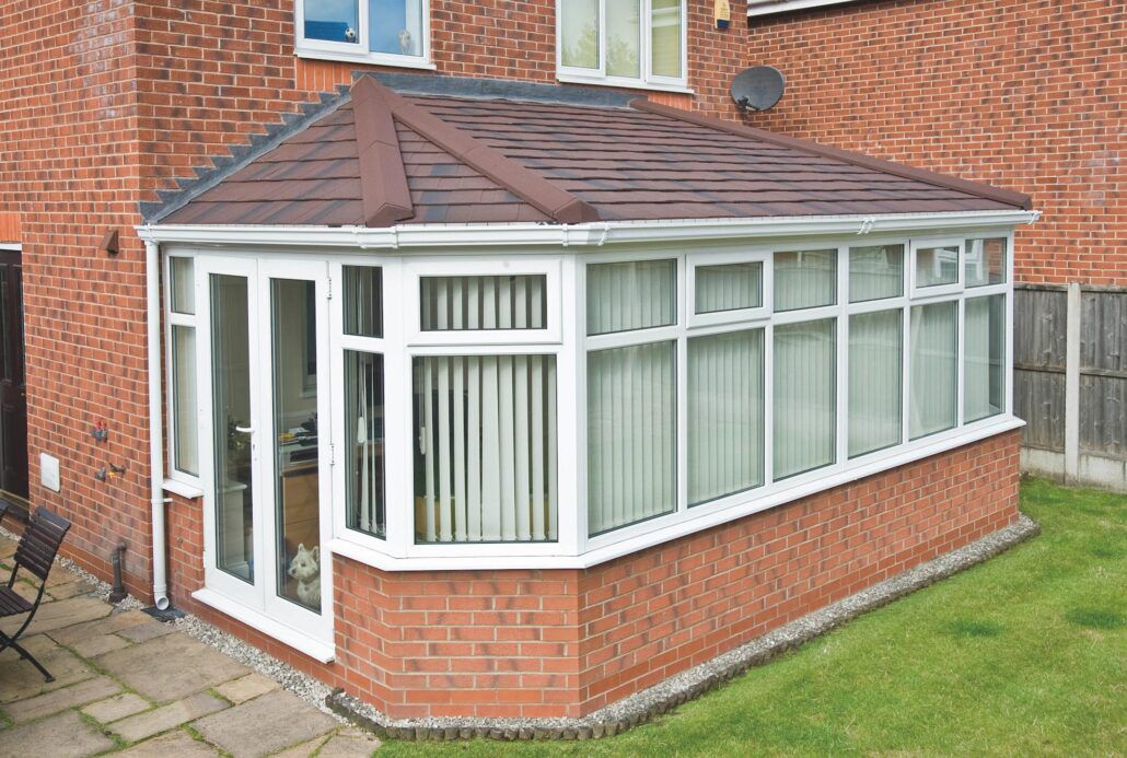 Conservatory with brown tiled warm roof and white uPVC frames