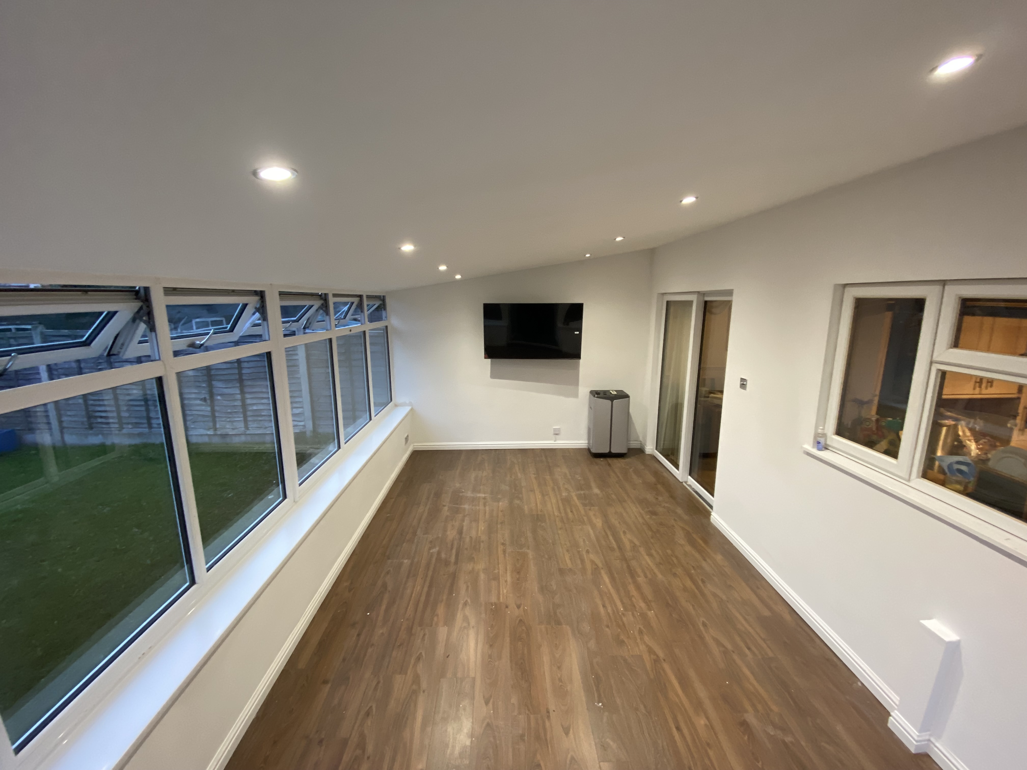 Finished conservatory living room with plastered ceiling and recessed spotlights