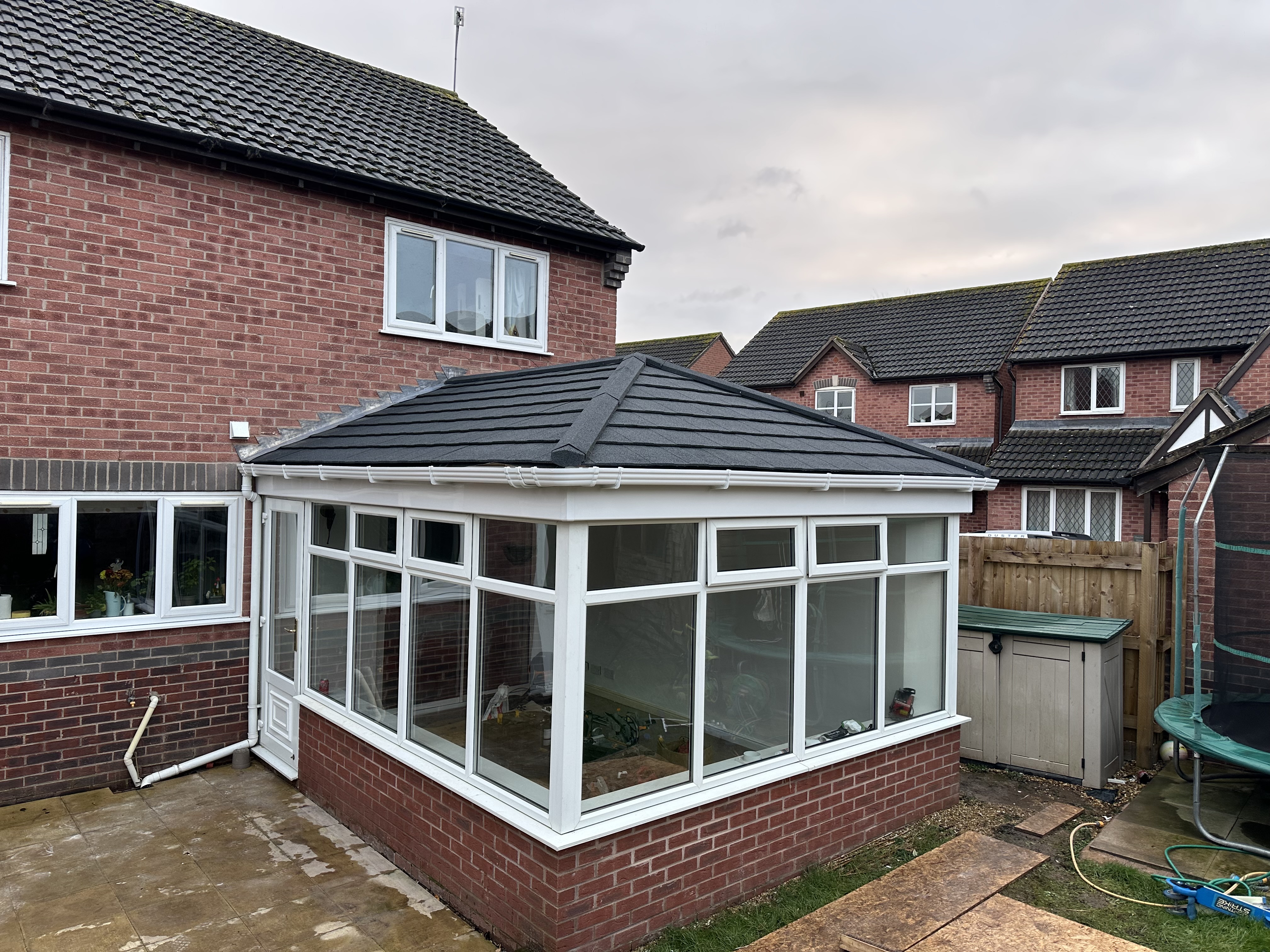 Conservatory with charcoal tiled warm roof and brick dwarf wall