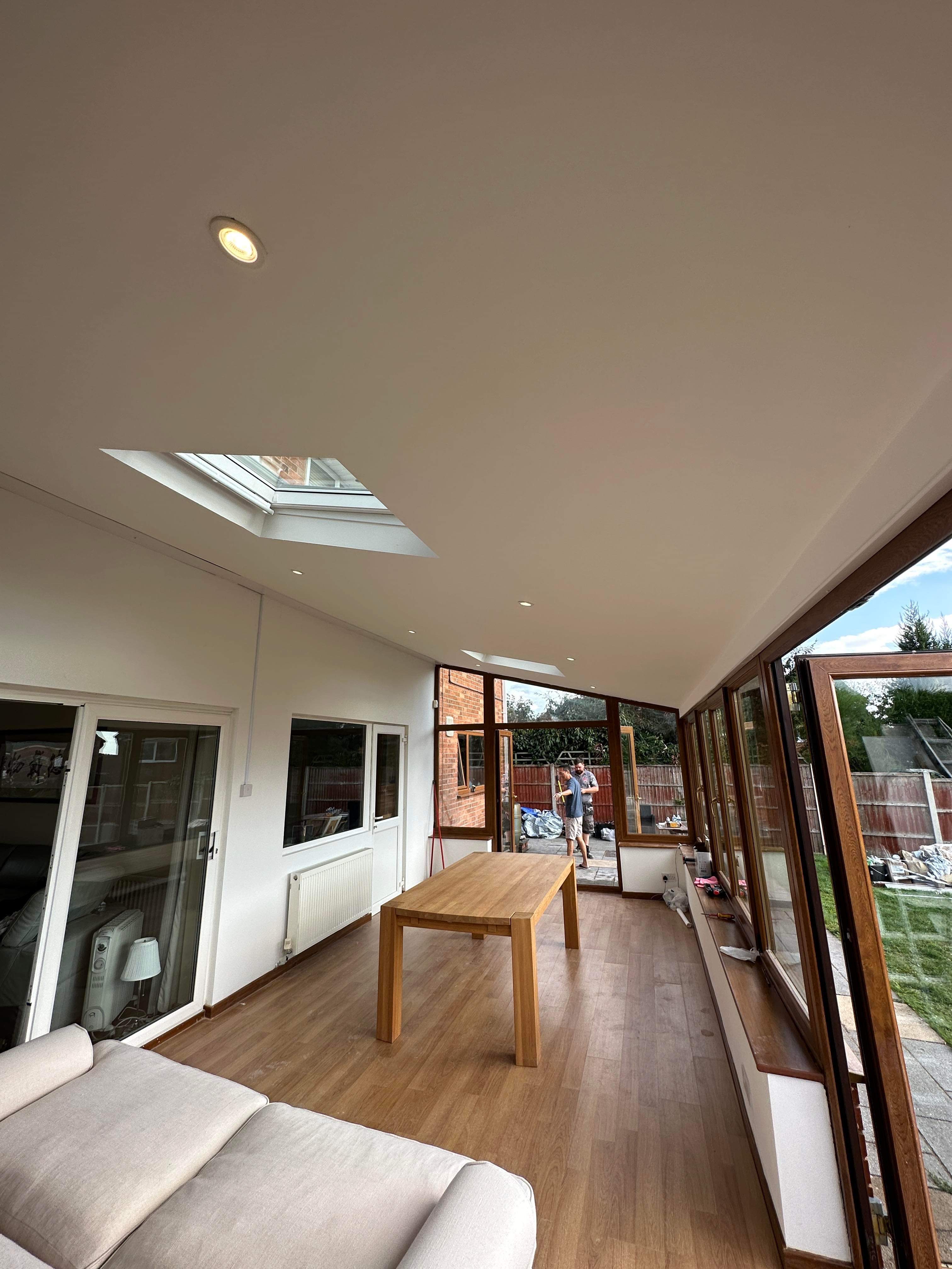 Conservatory dining room with skylights and plastered ceiling