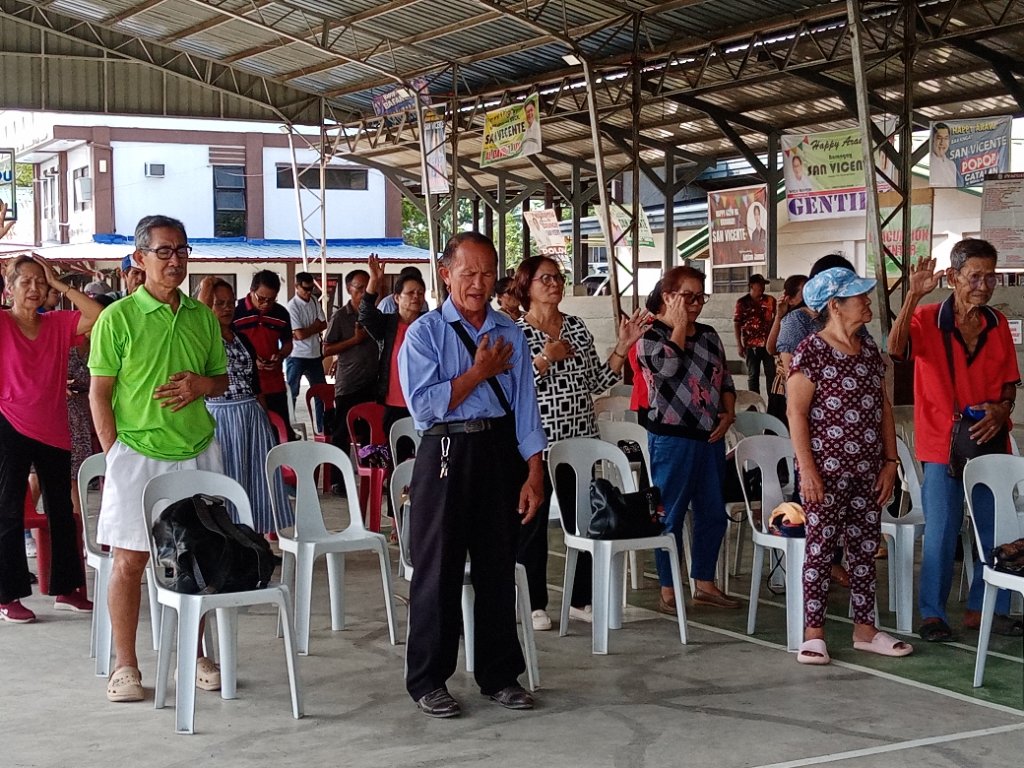 Worship assembly with hands raised in prayer