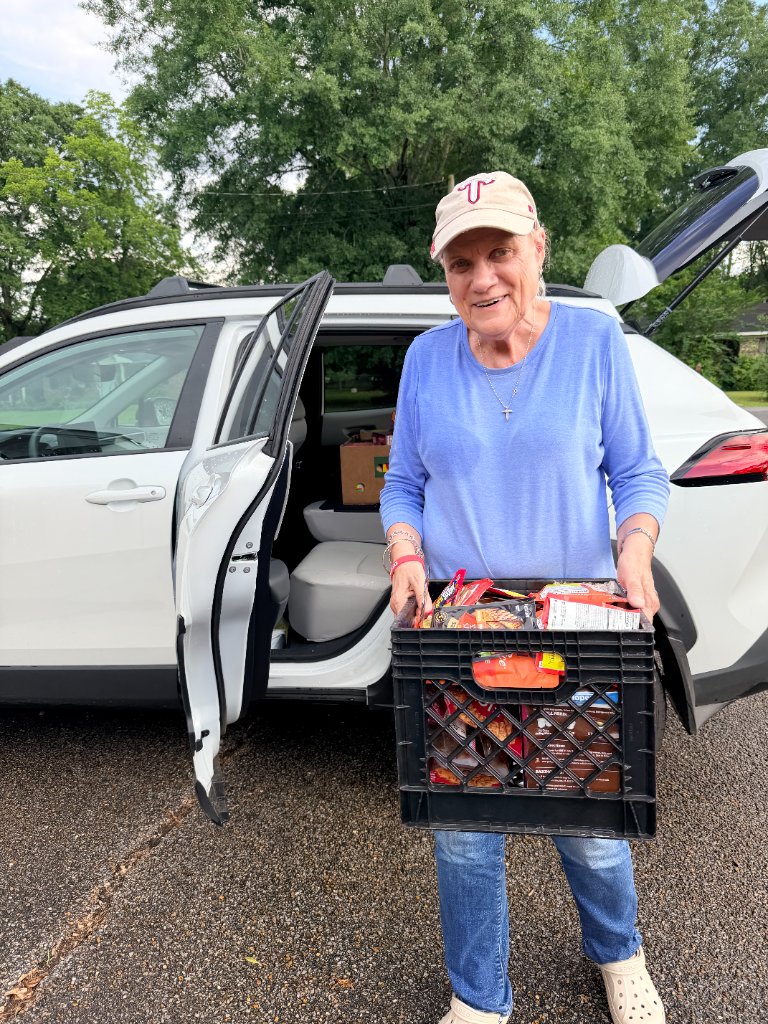 Volunteer greeting a community member at drive-thru