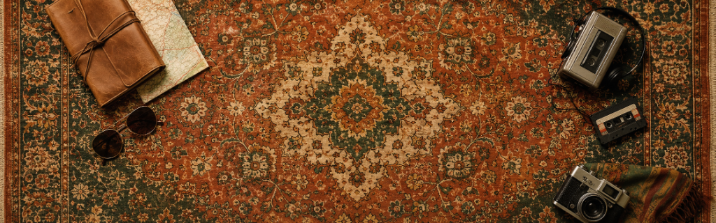 A Persian rug with sunglasses, a leather journal, and vintage cassette players