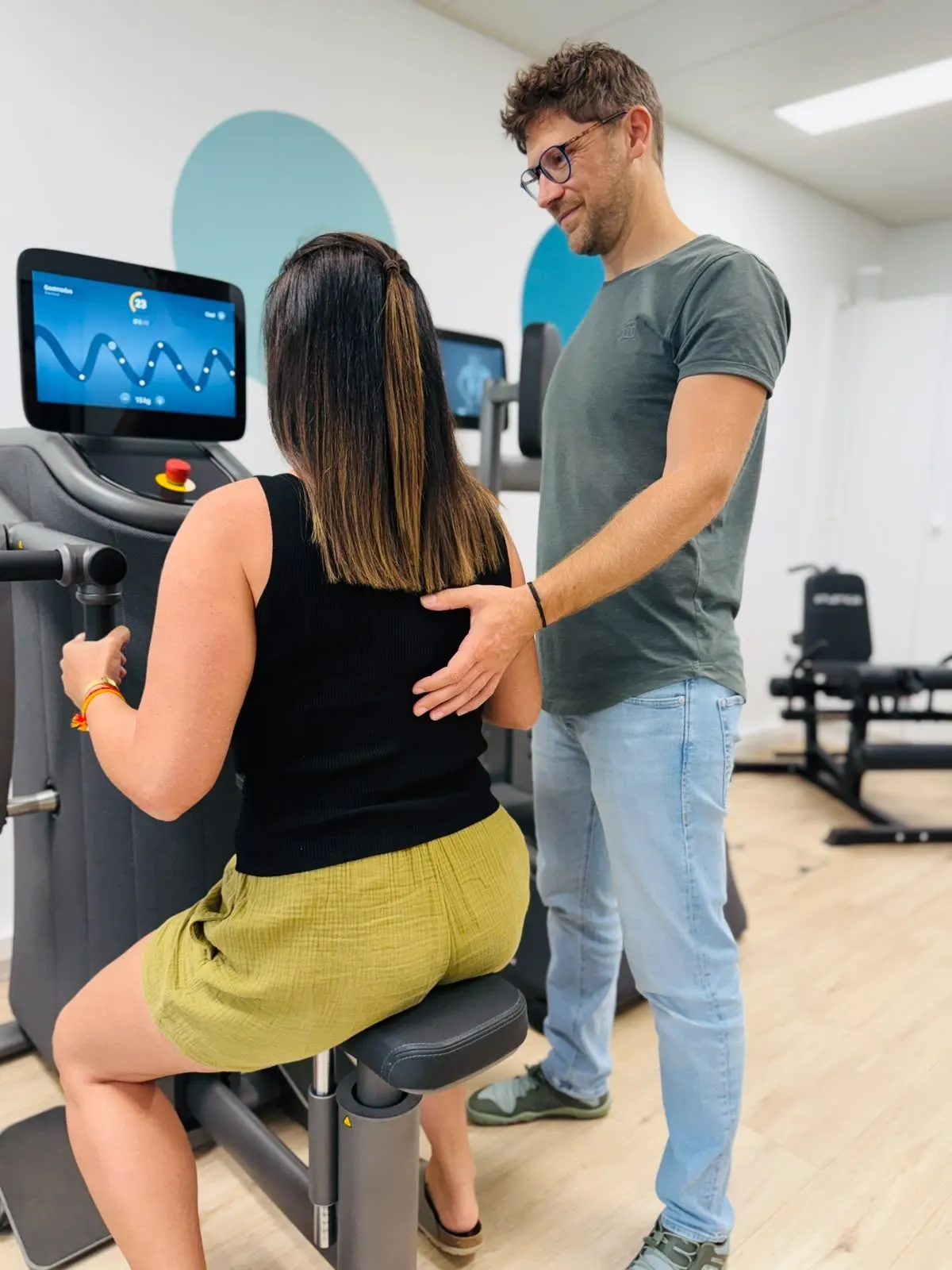 Jan Peters begleitet eine Klientin beim Training am EGYM-Gerät in der Praxis in Weinfelden