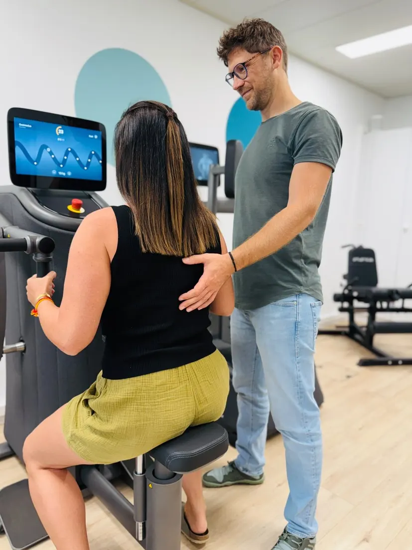 Jan Peters begleitet eine Klientin beim Training am EGYM-Gerät in der Praxis in Weinfelden
