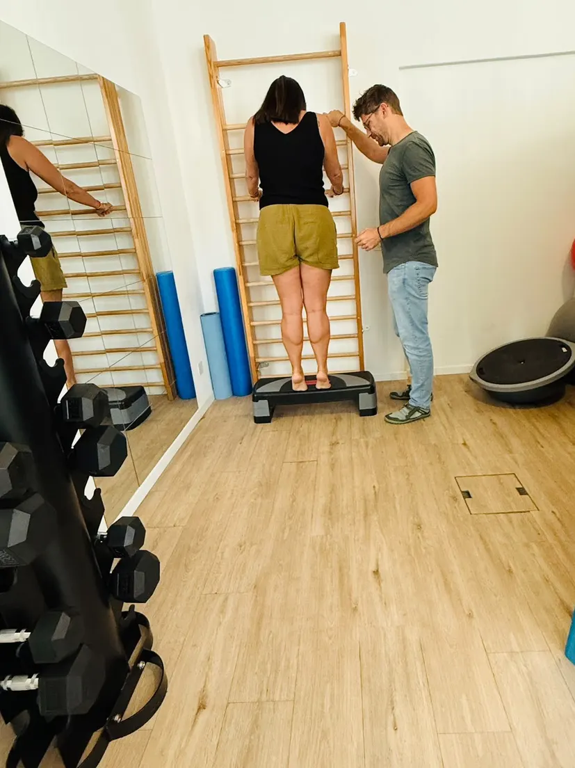 Physio Check-Up an der Sprossenwand: Jan Peters beobachtet eine Klientin beim Stehen auf dem Step