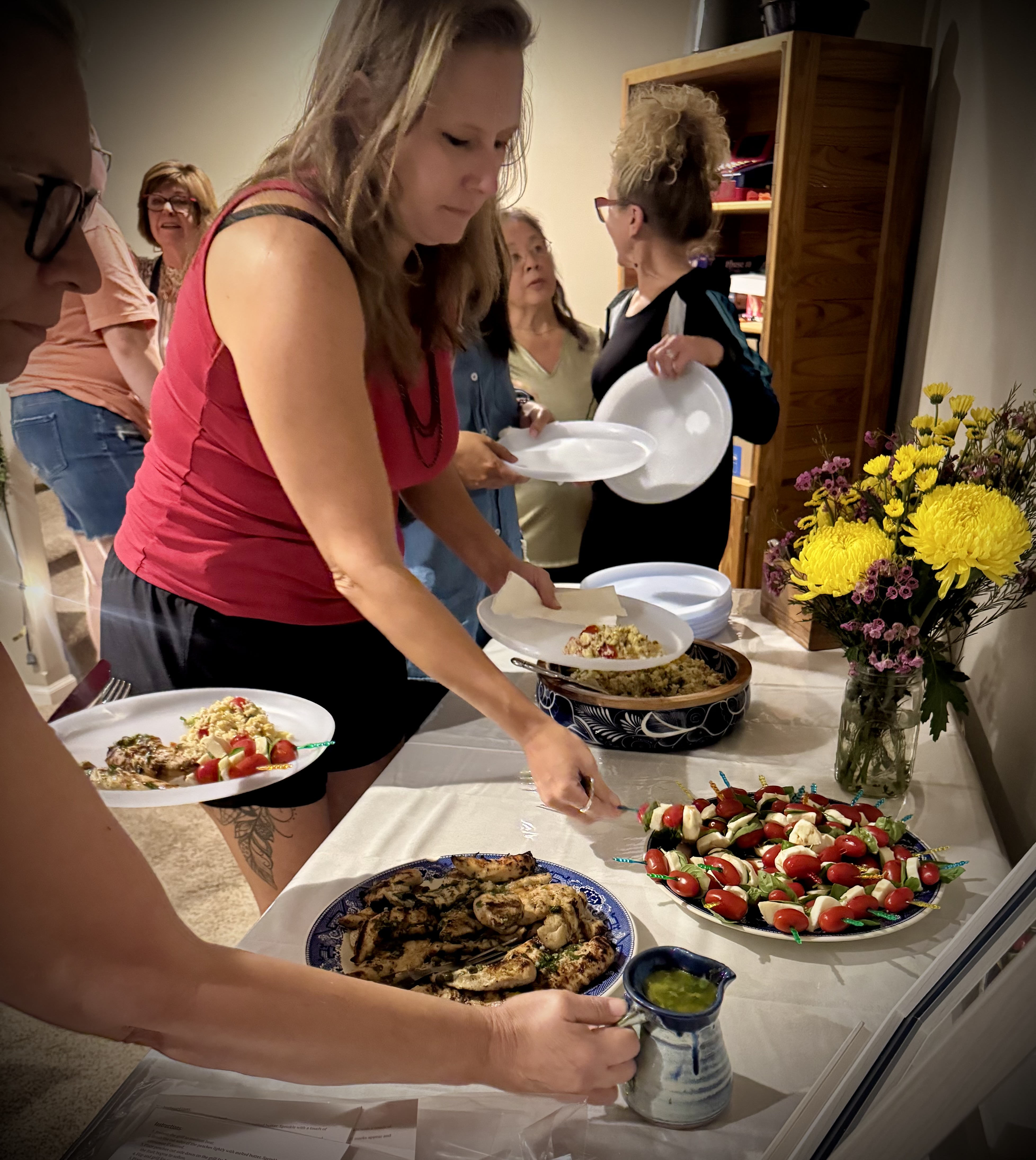 Women gathering around a table to share a meal